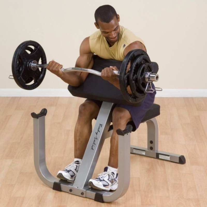 Body-Solid Preacher Curl Bench GPCB329 - Man watching his mucles happily while working out with arms