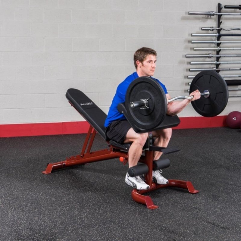 Body-Solid Preacher Curl Station GPCA1 - Man using the product while holding a barbell