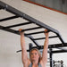Body Solid Pro Club Line Power Rack Double Rack/Extension w Monkey Bar - woman on monkey bar 