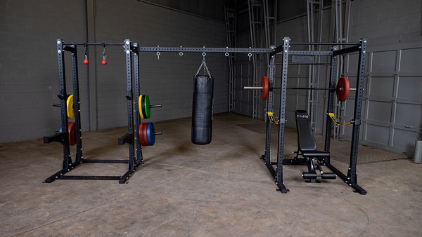 Body Solid Pro Club Line Power Rack, Half Rack Connecting Bar - different colored barbels on it 