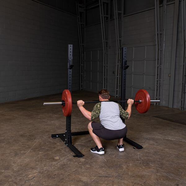 Body Solid Pro Club Line Squat Stand - man lifting a barbel 