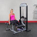 Body-Solid Pro Select Leg Extension Leg Curl Station GCEC-STK - Woman with leg a bit opened using the product