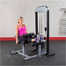 Body-Solid Pro Select Leg Extension Leg Curl Station GCEC-STK Woman resting her feet on cushioned rollers