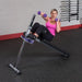 Body-Solid Pro-Style Ab Board GAB60 - Woman curl up with punching dumbbells