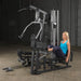 Body-Solid Single Stack Gym G5S - Woman in blue top sitting doing leg press