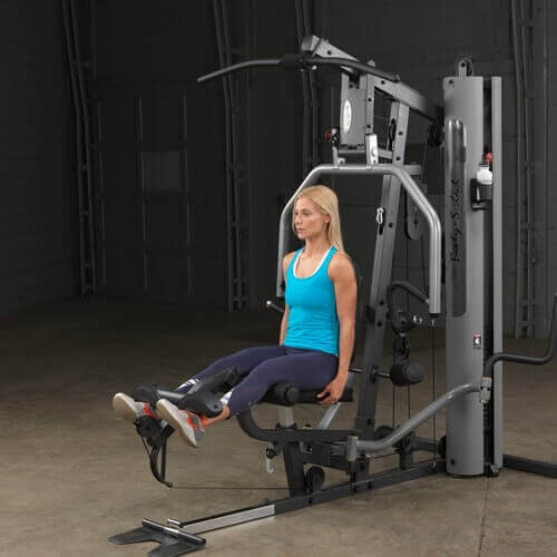 Body-Solid Single Stack Gym G5S - Woman sitting on bench with her legs raised pulling weights