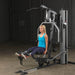 Body-Solid Single Stack Gym G5S - Woman sitting on bench with her legs raised pulling weights