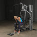 Body-Solid Single Stack Gym G5S - Woman sitting on bench while pulling weights from her back