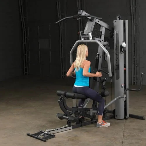Body-Solid Single Stack Gym G5S - Female model in blue tank top sitting while doing upper body workout