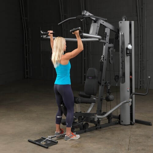 Body-Solid Single Stack Gym G5S - Female model in blue top standing in front of G1S lifting weights