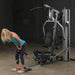 Body-Solid Single Stack Gym G5S - Woman pulling weights from her back while standing up