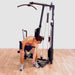 Body-Solid Single Stack Home Gym G1S - Man pulling metal string for weights below G1S