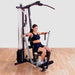 Body-Solid Single Stack Home Gym G1S - Woman sitting on bench doing lateral arm exercise