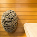 HUUM DROP Series 7.5kW Sauna Heater Package - A metal basket full of sauna stones attached to a wooden wall