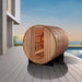 Golden Designs "Zurich" 4 Person Barrel with Bronze Privacy View - Traditional Steam Sauna - Pacific Cedar - a wooden barrel with a door open on a deck with a pool and a building