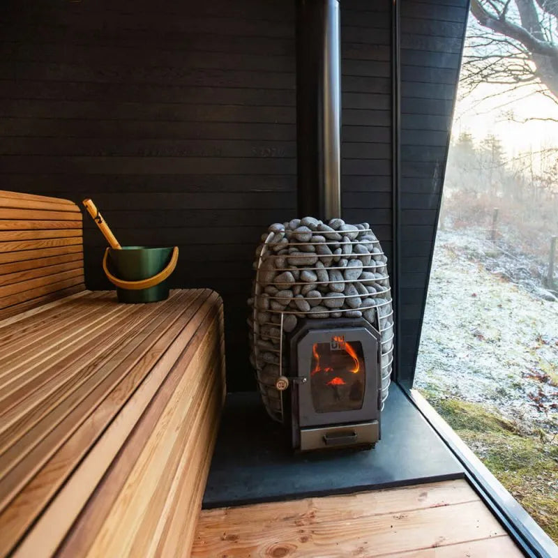 HUUM HIVE Wood 17 Wood Burning Sauna Stove - outdoors next to a wooden bench