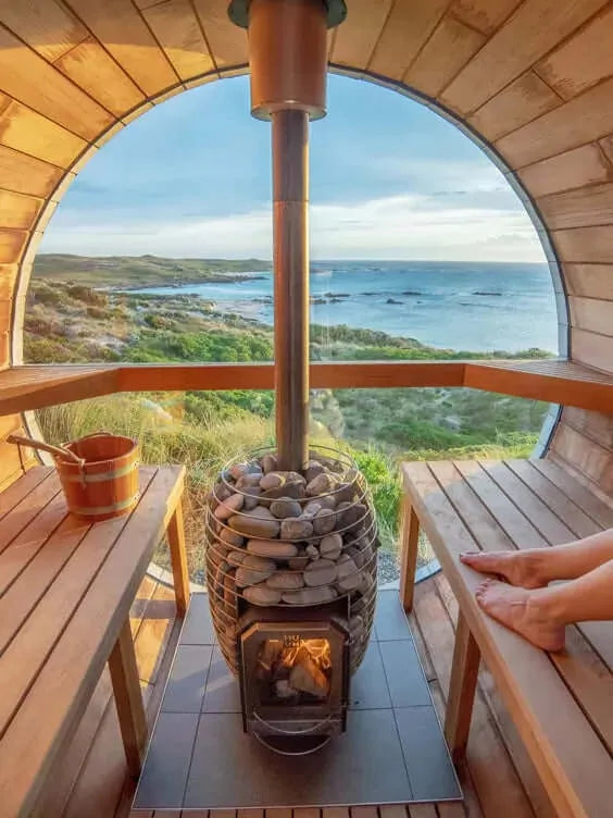 HUUM HIVE Wood Series 13kW Sauna Heater Package -a wood stove with a wood tub and a view of the ocean