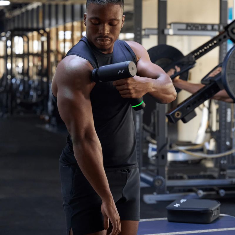 Hyperice Hypervolt 3 Pro - a man in a gym using Hypervolt on his right arm
