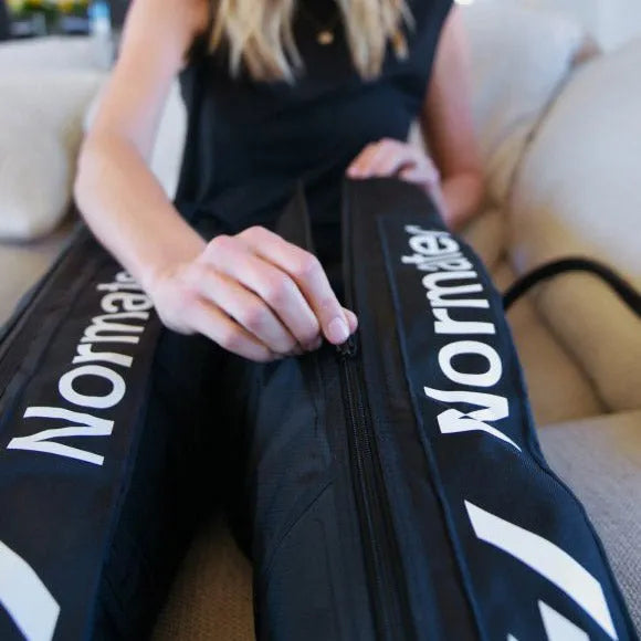 Hyperice Normatec 3 Leg Recovery System - A woman opening the zipper of leg recovery system