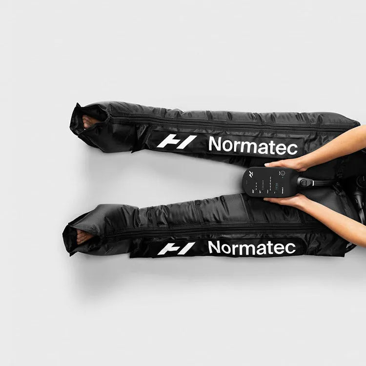Hyperice Normatec 3 Leg Recovery System -  a person sitting on a white background holding a device