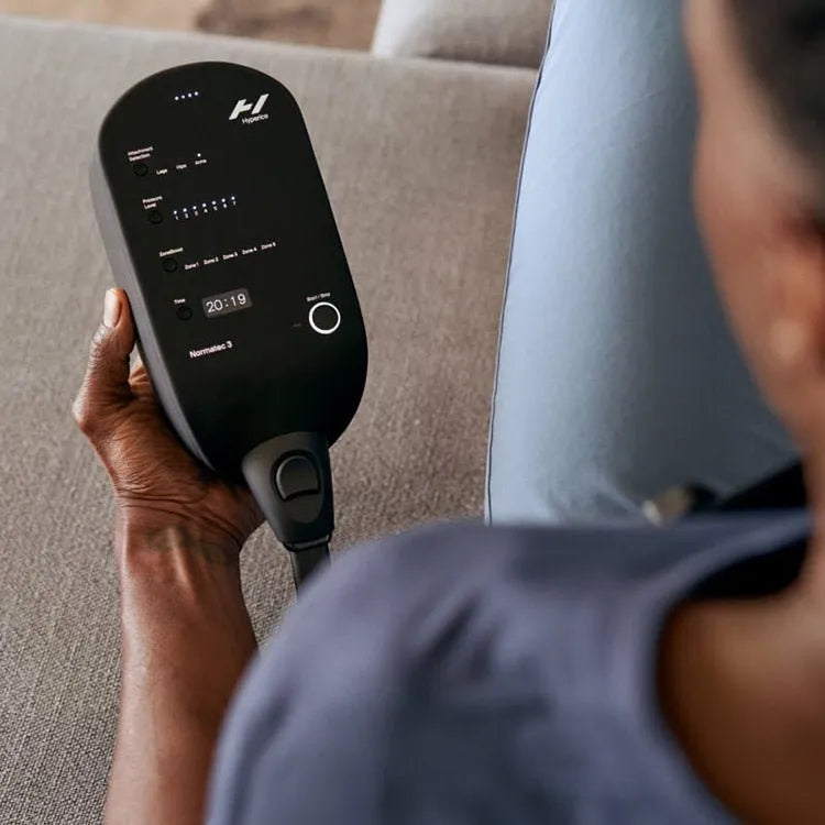 Hyperice Normatec 3 Leg Recovery System - A person holding the control