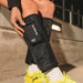 Hyperice Normatec Go - A person wearing yellow shoes wearing the device on both legs