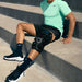 Hyperice X 2 Knee - Worn by a man sitting outdoor on concrete steps
