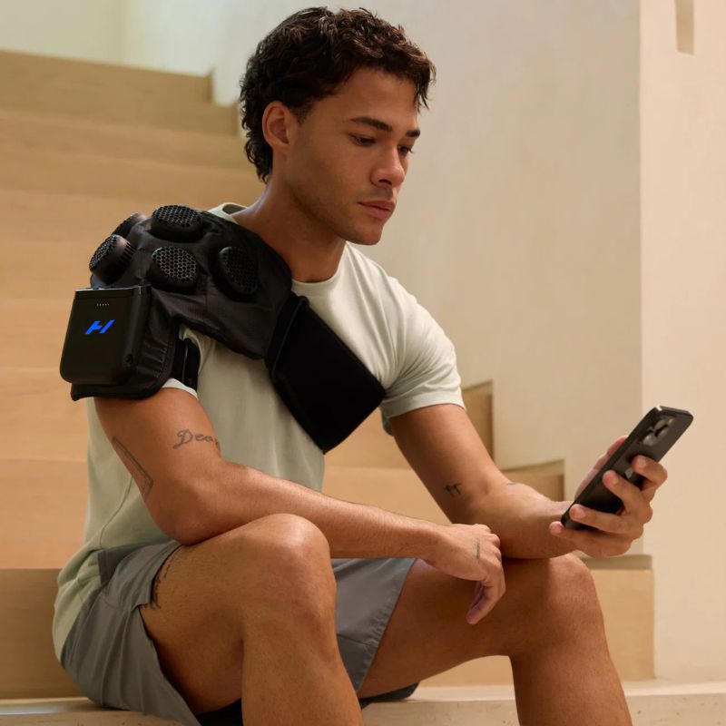 Hyperice X 2 Shoulder- man sitting using a phone