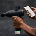Hypervolt 2 Pro Massage Gun - A man holding massage gun and a phone
