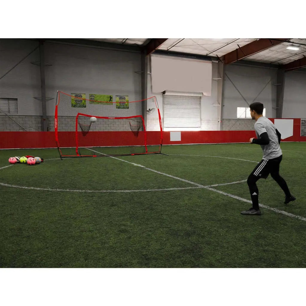 A boy playing indoor soccer using Powernet 16x10 Ft Soccer Goal Combo Barrier 1214