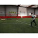 A boy playing indoor soccer using Powernet 16x10 Ft Soccer Goal Combo Barrier 1214
