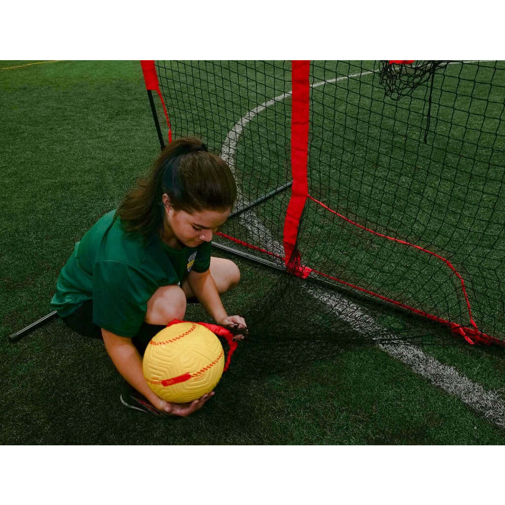 A girl holding a soccer ball beside Powernet 16x10 Ft Soccer Goal Combo Barrier 1214