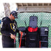 A person holding baseball bats beside Powernet All Gear Transporter Rolling Baseball Equipment Bag for Coaches B007