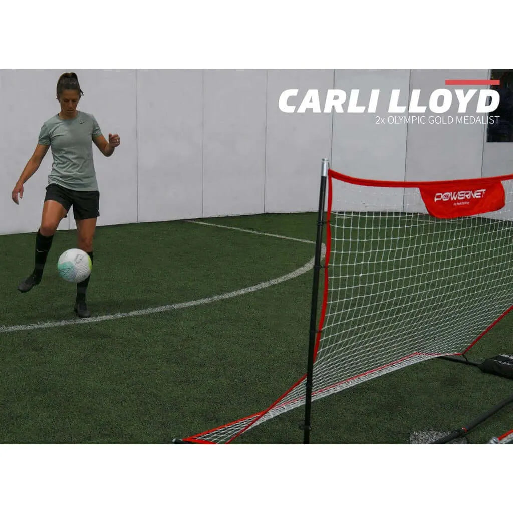 A girl playing soccer indoors is using Powernet Fast Pass Rebounder Soccer Trainer 6x4 FT 1126
