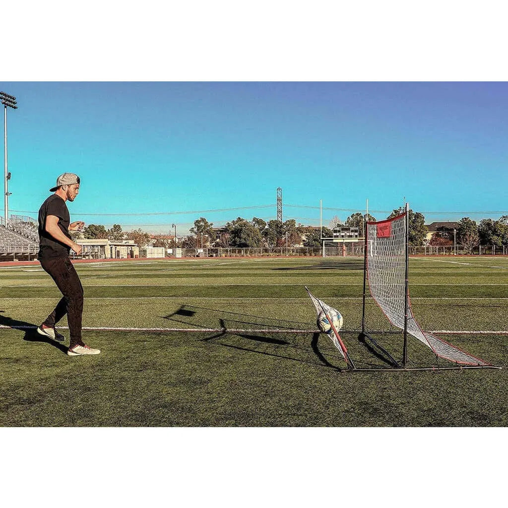 Powernet Training Net 6' x 4' Fast Pass Rebounder Trainer Soccer Bundle - A man playing soccer in an open field on a sunny day