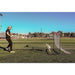 Powernet Training Net 6' x 4' Fast Pass Rebounder Trainer Soccer Bundle - A man playing soccer in an open field on a sunny day
