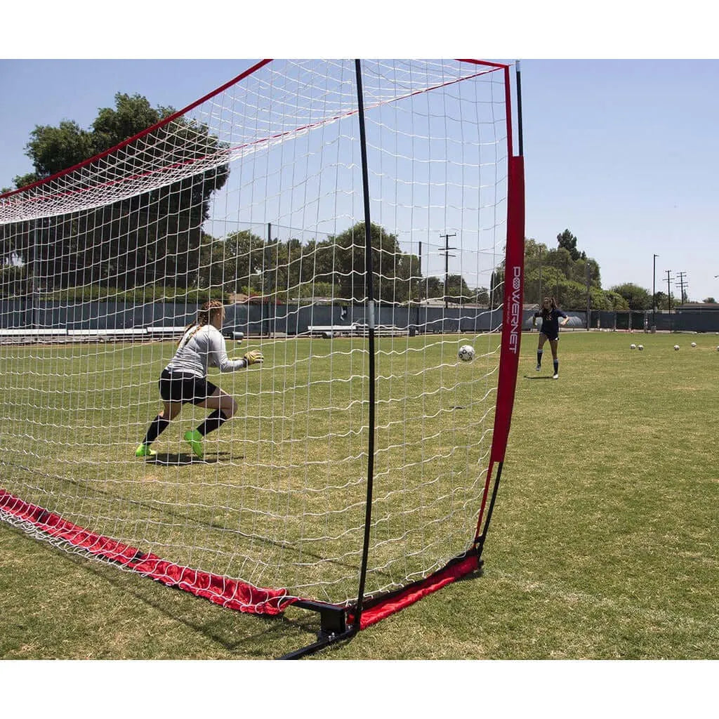 Side view of Powernet Soccer Goal Regulation Size 24x8 Net S007 in an open field with two girls playing soccer