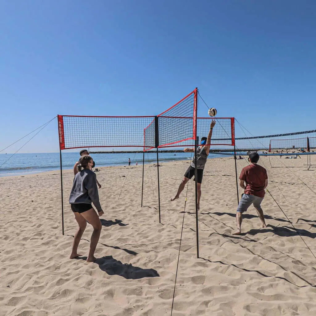 Four people playing beach volleyball using Powernet Volleyball Four Square Net