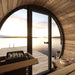 SaunaLife Model EE6G Sauna Barrel - a wooden sauna with a door open to the water