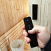 SaunaLife Model X6 Indoor Home Sauna - a hand holding a remote control