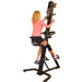 VersaClimber SRM Sport Rehab Model - Back view of a woman sitting on a black exercise machine