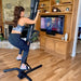 VersaClimber TS Magnetic Commercial Vertical Climber - a woman exercising on a exercise bike while watching TV