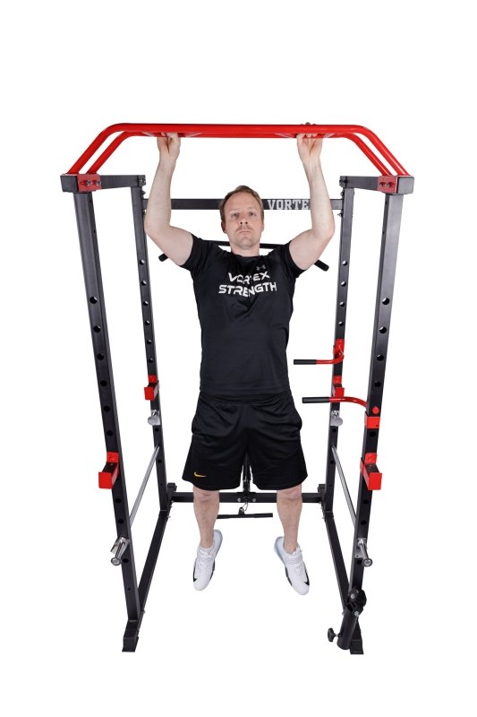 Vortex Strength Power Rack Full Set (Cage + Barbell + Plate Set + Adjustable Bench) - Front view with a man working out in pull up 