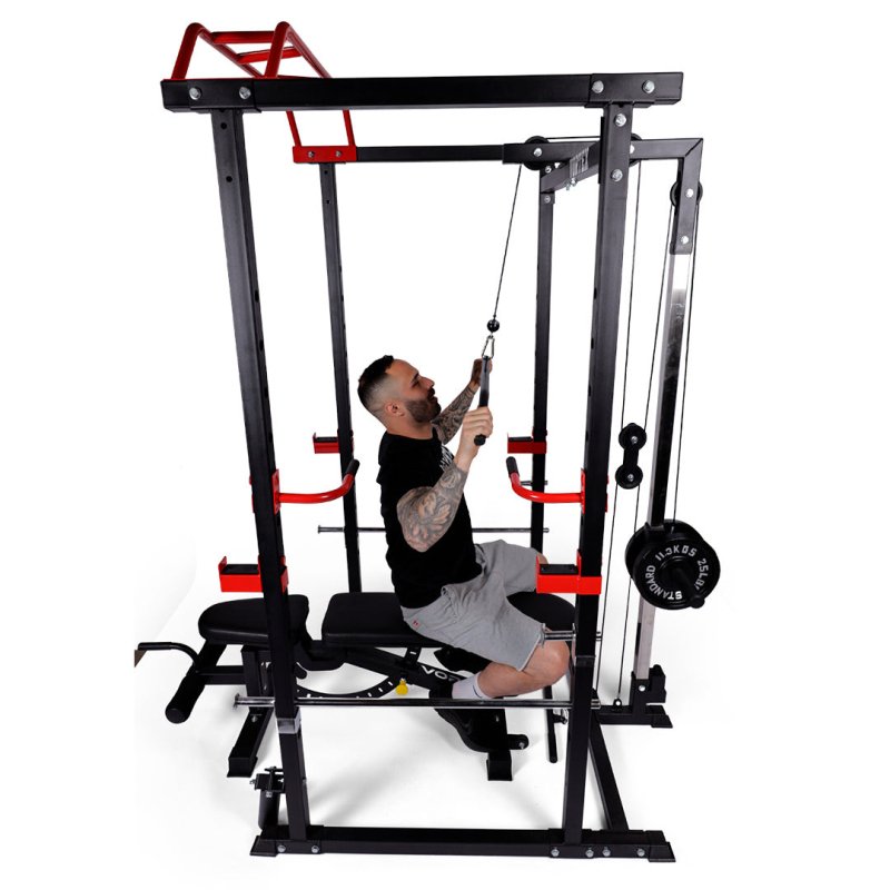 Vortex Strength Power Rack Full Set (Cage + Barbell + Plate Set + Adjustable Bench) - Side view photo of the product with a man inside pulling the lat attachment