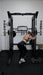 Vortex Strength VX1000 Smith Machine and Functional Trainer -  woman working out holding the side of the machine