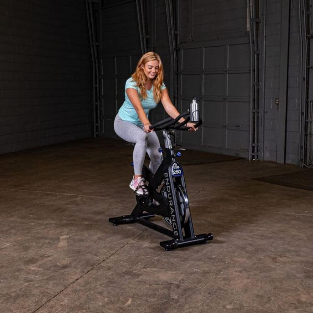 Body-Solid Endurance Spin Bike ESB250 - woman on bike holding the handles