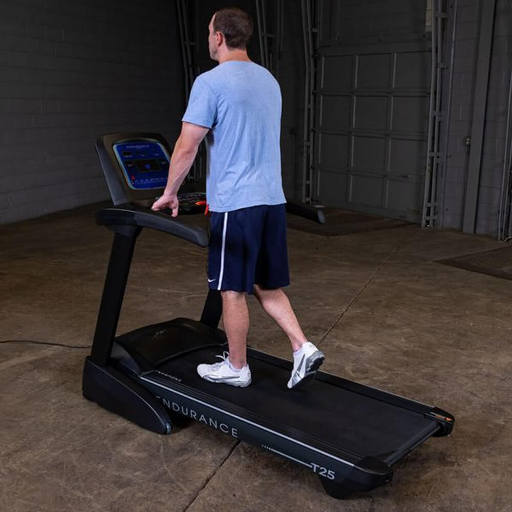 Body-Solid Endurance Folding Treadmill T25 - man standing on the running belt