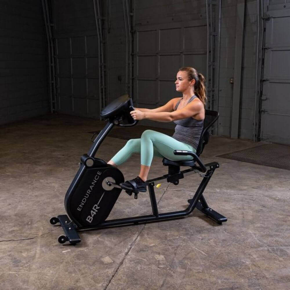 Body-Solid Endurance Recumbent Bike B4RB - woman using the machine and hands on the  handle