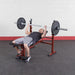 Best Fitness BFOB10 Olympic Bench With Leg Developer  - Man on bench  holding the barbell rod