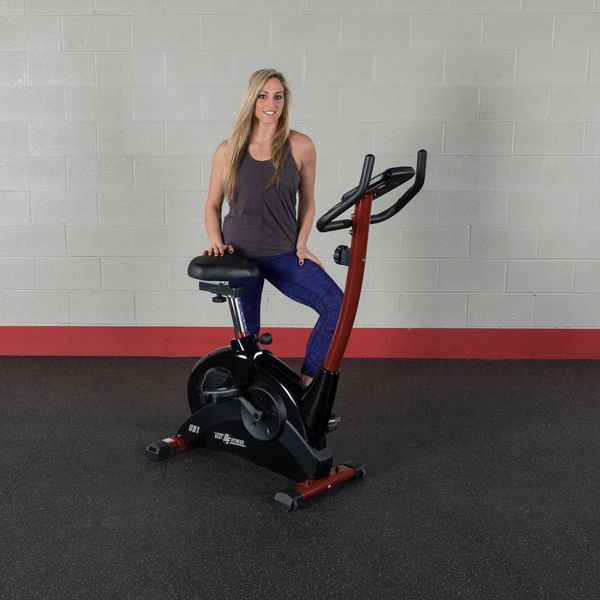 Best Fitness BFUB1 Upright Bike - woman standing behind the product while right hand on the seat